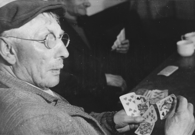 876597 Portret van een kaartende man, tijdens een vaderavond in een zaaltje van het St. Franciscushuis (Oudegracht 23) ...